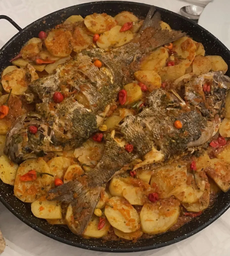 Poisson entier rôti aux pommes de terre, tomate et piments, à la plancha.
